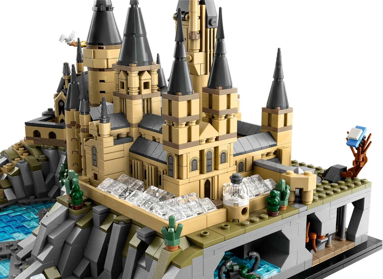 Detailed LEGO model of Hogwarts Castle and Grounds featuring towers, rocky terrain, and water elements.